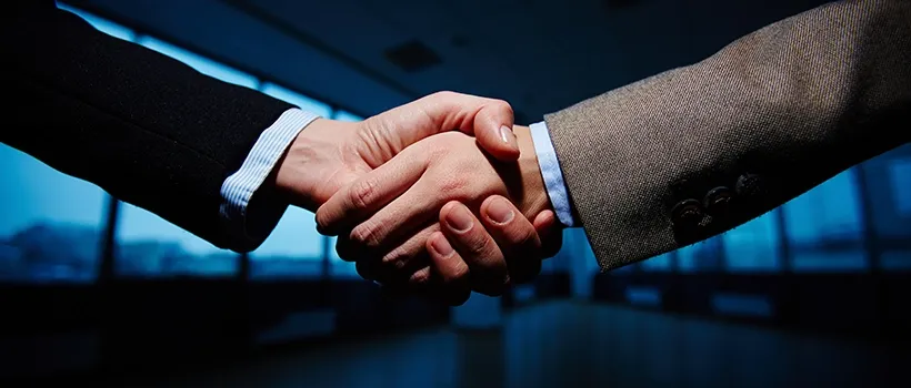 handshake symbolizing the Broadcom acquisition of VMware